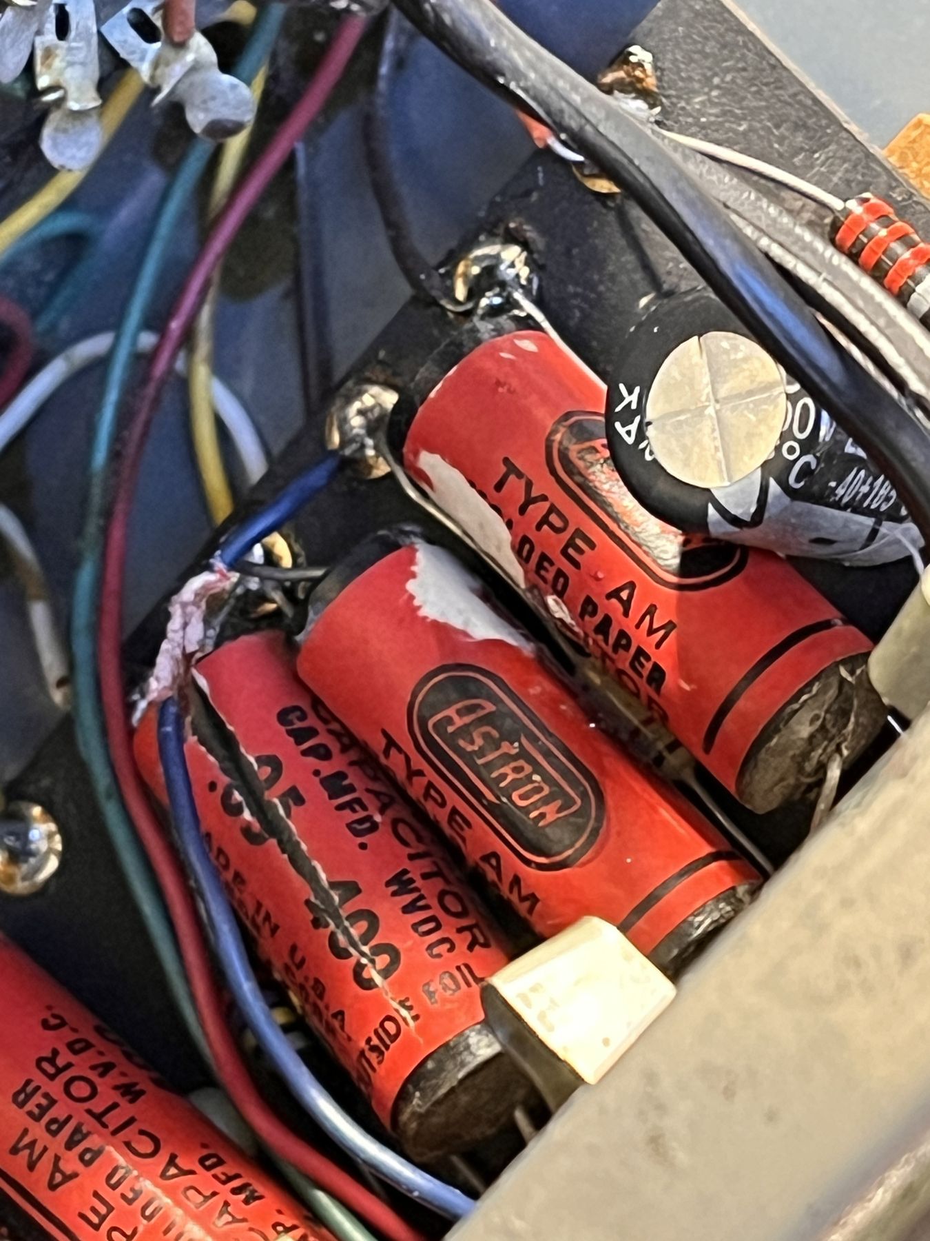 Original Astron paper coupling capacitors in the Ampeg M-15, showing cracked wax coating on units that tested as leaking