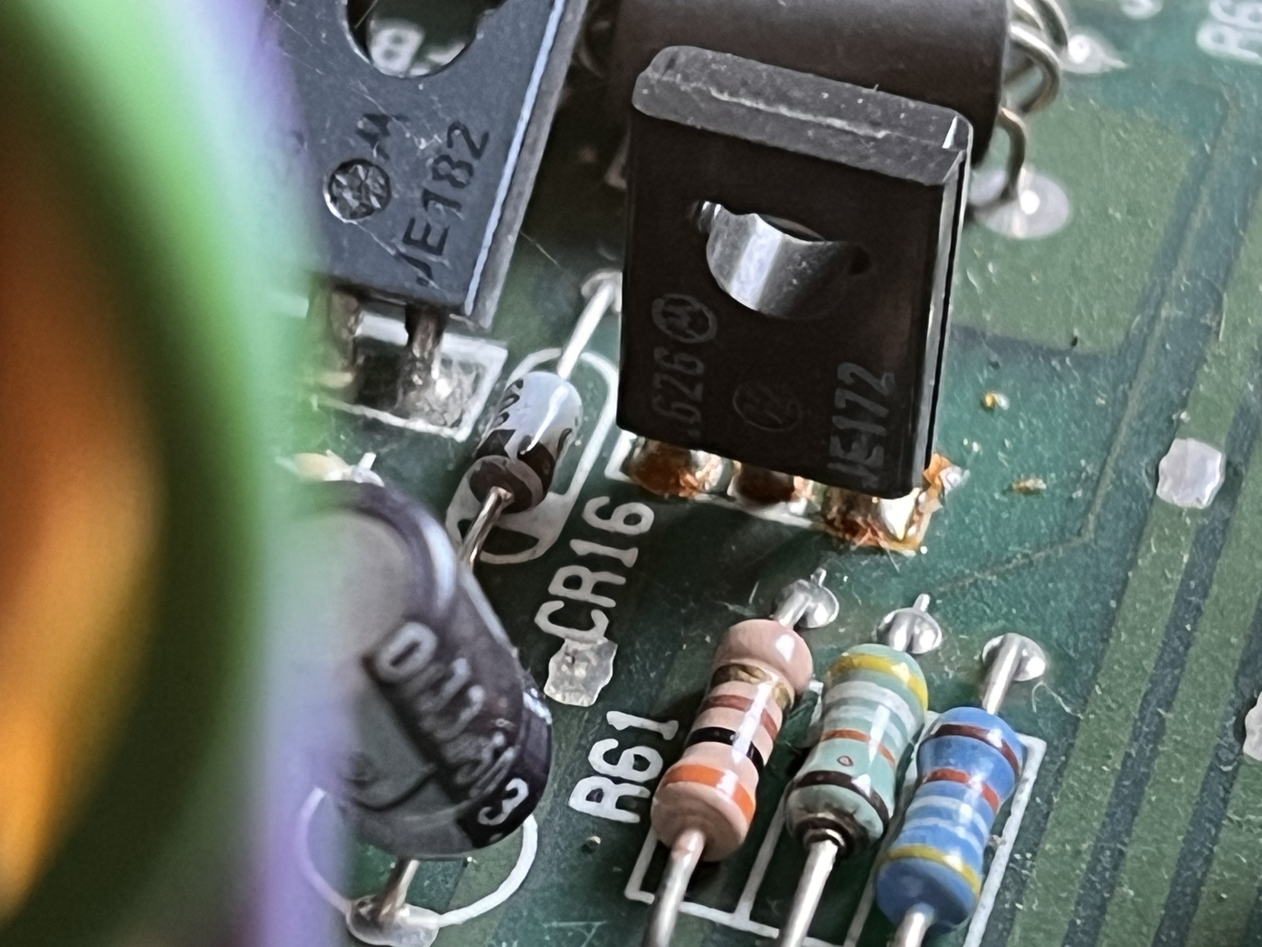 Close-up of MJE182 and MJE172 transistors Q10 and Q11 with heat damage visible around Q11