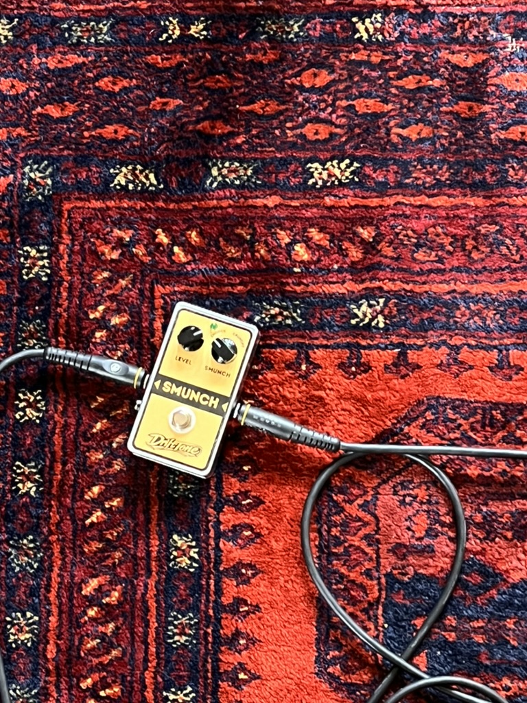 DriftTone Smunch pedal plugged in on a red rug